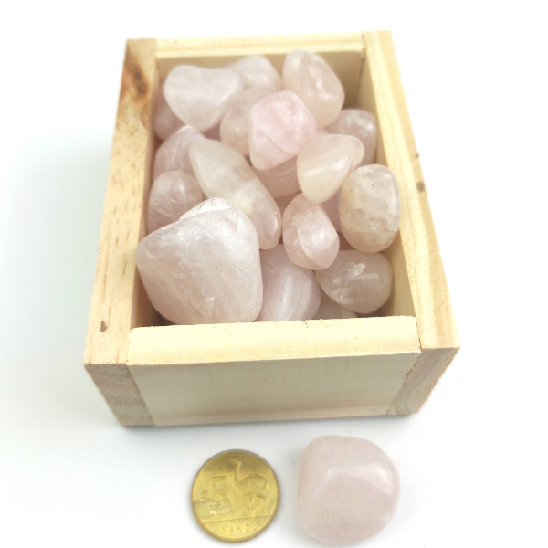 Piedras roladas de cuarzo rosa en una caja de madera